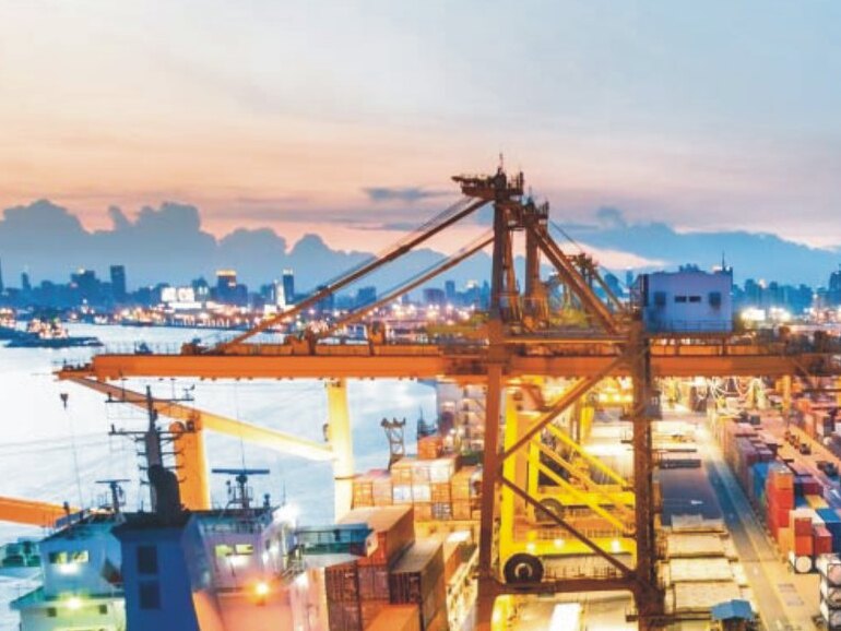 Container port at dusk with gantry cranes and a cargo ship